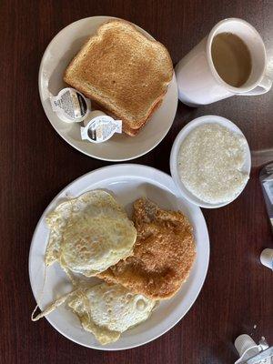 Pork chop breakfast with grits, eggs, & toast.