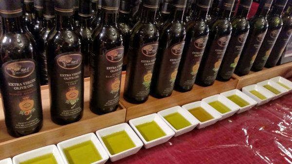 Selection of Greek olive oils, infused with a variety of herbs, fruits, and spices.