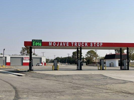 Mojave Truck Stop. Diesel price sign on the canopy, diesel pumps, truck repair on the left, and the convenience store on the right.