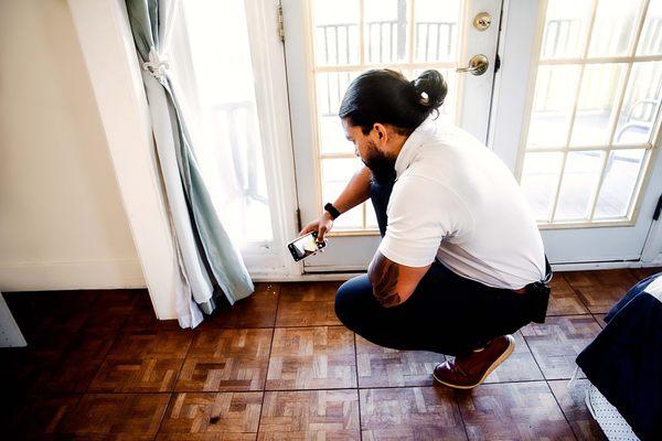 Investigating and capturing moisture damage near the balcony door.