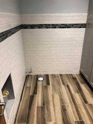 3x6 white subway wall tile w/ glass mosaic accent. 6x36 porcelain wood look plank floor tile.