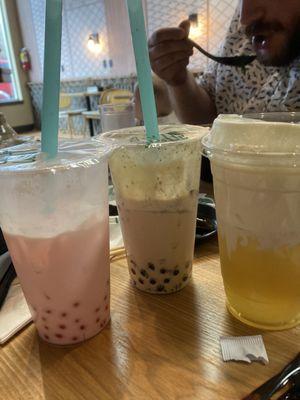 Strawberry milk tea with popping strawberry boba, brûlée Oreo milk tea, and peach tea with cheese foam.