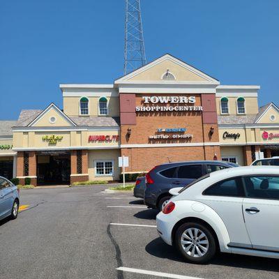 Outside in the parking lot of Towers Shopping Center. You can see the red bright sign of SUPERCUTS on the left side of the building.