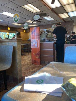 Chips, sign, light, window, chair, chair, napkin, chair, chair, underpaid subway worker, underpaid subway worker