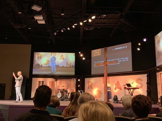 The front stage of the church w/ tv monitors and a live band.