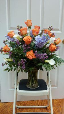 Special design for a special occasion..with orange roses and white calla lilies..our family favorite!