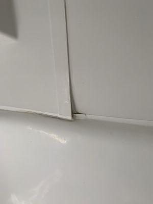 Open slits from the bathtub that cause water leakage and mold