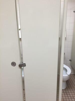 Bathroom stall door has big gap. Not much privacy.