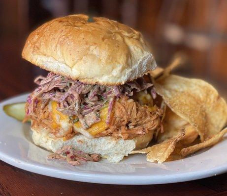 Barbecued pulled chicken with coleslaw and a slice of pineapple.