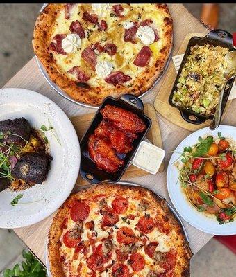 A spread of entrees, sides, and pizzas