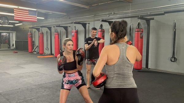 Female members holding Thai pads