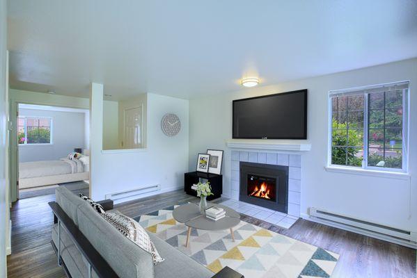 Living room with open floor plan, electric fireplace and luxury vinyl plank flooring.