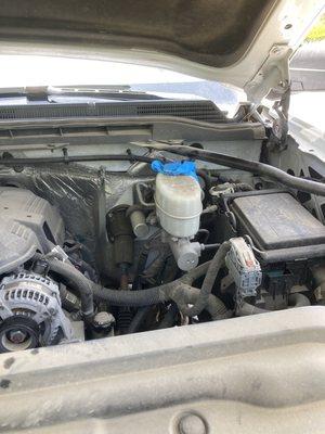 Rubber glove covering the master brake reservoir where the cap should be.