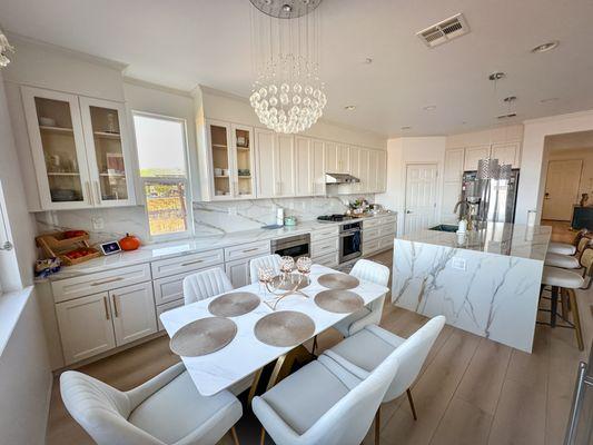 Bright kitchen with white cabinets, marble countertops, and a large island. A perfect blend of functionality and luxury for modern living.