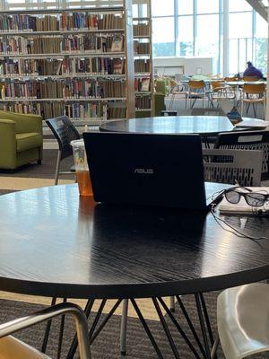 A desk being occupied with a drink