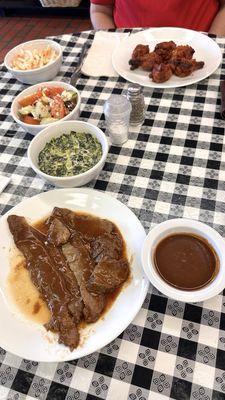 Brisket, Greek salad and chicken wings for a shared lunch.