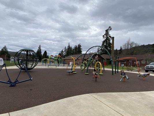 Playground in forefront, splash pad in back