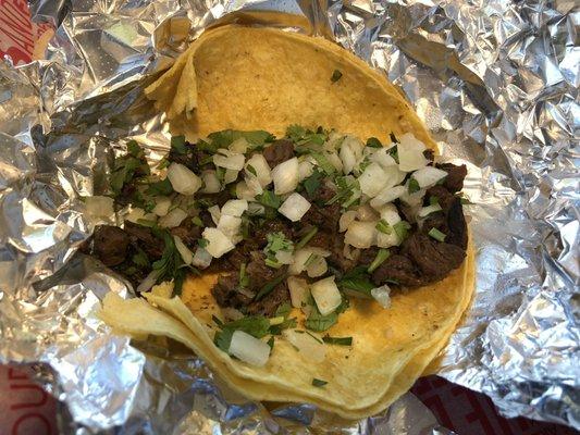 Steak taco with onions and cilantro.