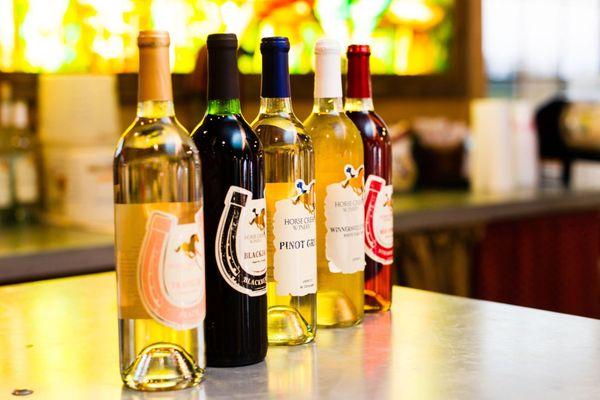 A lineup of our popular Horse Creek wines! Winnersville White (Muscadine White), Miss Blue (Blueberry), and Traveler (Peach).