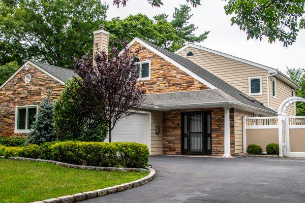 Charter Oak vinyl siding by Alside with Boral cultured stone masonry accents. GAF Weatherstopper Roofing System with Golden Pledge warranty.