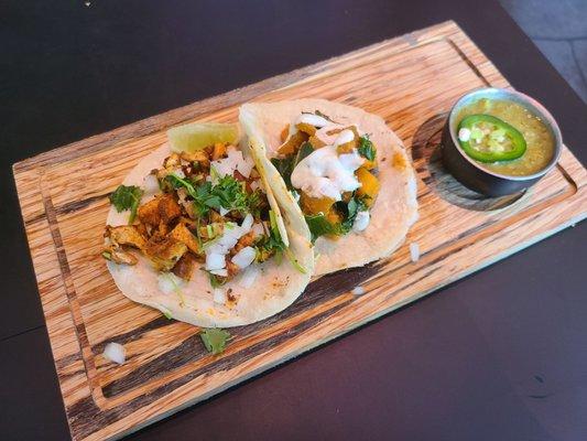 Pollo Asado Taco (tangy achiote-rubbed grilled chicken, cilantro, onion) and Squash, Kale, and Mushroom Taco w/cumin lime crema