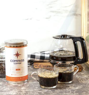 Compass Medium-Roast Cardinal Blend Whole Bean Tin and Black Coffee in Mugs