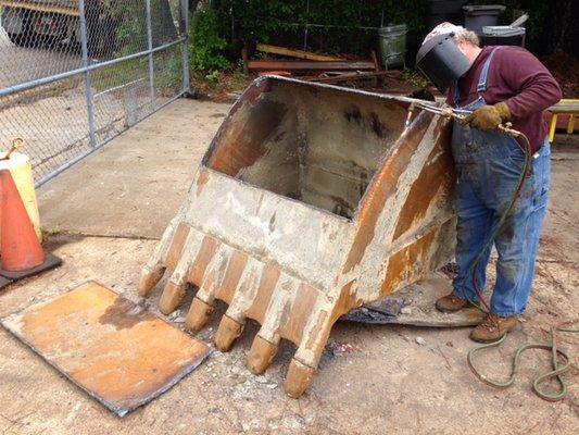 Bucket repair removal of worn bottom