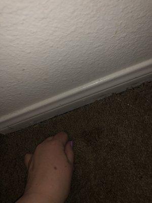 Carpet got pulled from wall after he made repairs. No longer goes under baseboard