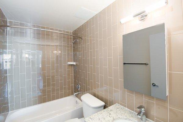 1430 W Apartments tile Bathroom with tub/shower, sink, toilet and large mirror