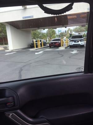 The "closed" drive through appears to be open with the employees parked cars.  Here's a suggestion: park them backwards or orange come them.