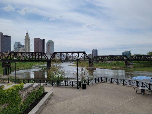 Skyline, river,  and glimpse of umbrella tables to the right.