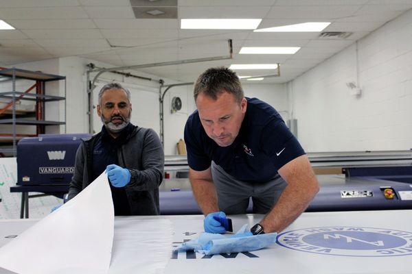 Teamwork in action! Our dedicated owner and print production manager collaborating to fulfill your signage needs.