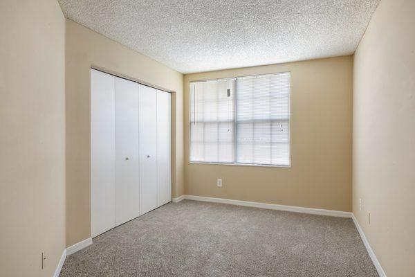 Bedroom with large reach-in closet and carpet flooring