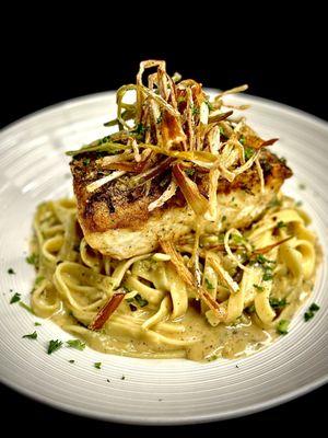 Cacio e Pepe Halibut * Halibut on top of a bed of pasta tossed in a black pepper and parmesan cream sauce, finished with fried leeks