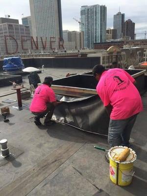 Commercial Roofing on a high rise building in Downtown Denver- here M&R Roofing staff members are adding EPDM Rubber to the roof!