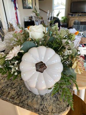 Backside of arrangement with picture of white ceramic pumpkin vase.