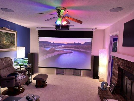 The projector, screen, and both tower speakers. The subwoofer is behind the seating.