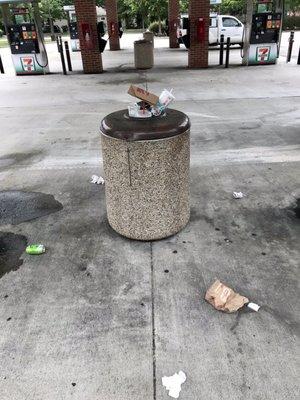 A disaster today, all three cans overflowing with trash on the ground.