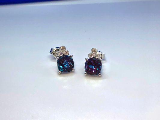 Alexandrite earrings set in 14 karat white gold with a three diamond accent.