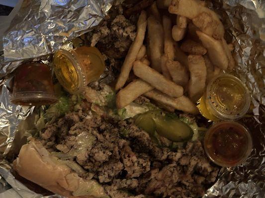 CCHEESESTEAK with fried onions and some sub toppings. Steak fries with oil and pepper sauce for dipping.