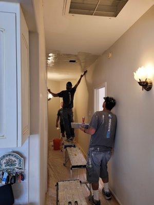 Brenner crew repairing hallway drywall ceiling.