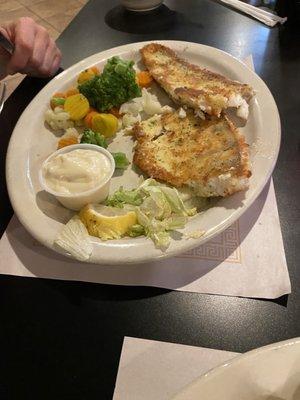 Half eaten Walleye fish entree with veggies.