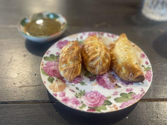 Sampling three fresh baked empanadas with the addictive chimichurri sauce.