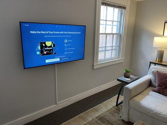 50" TV mounted with a cord cover on drywall-covered brick.