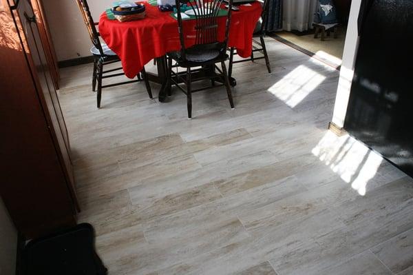 No wax floor removed and replaced with 6-1/2" x 40" porcelain glazed tile that has a wood grain finish.