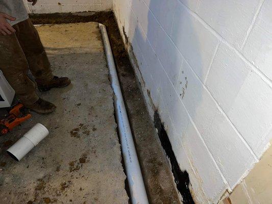 Perforated pipe is installed underneath the floor and is sloped to a pump to take away any water penetrating the foundation.