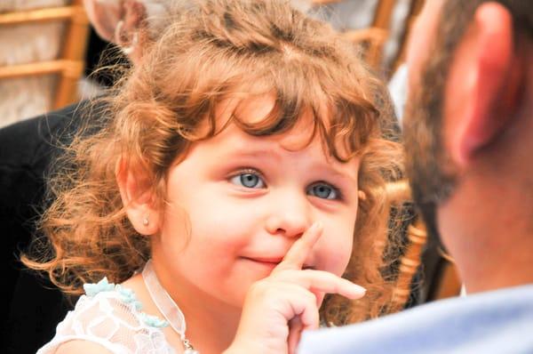 This adorable flower girl makes sure her dad knows to be quiet during the ceremony.