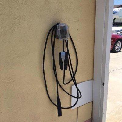 This is a 50 amp Tesla car charger located outside of the garage but behind the gate