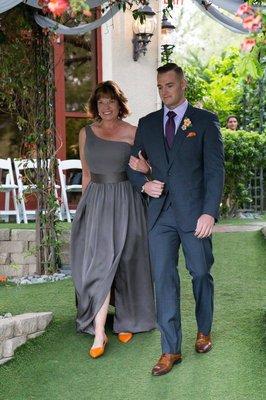 My son's wedding as he is walking me to my seat. Thank you to the wonderful seamstress for making this dress fit perfectly.