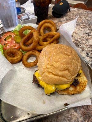 Cheeseburger, homemade bun, and onion rings.